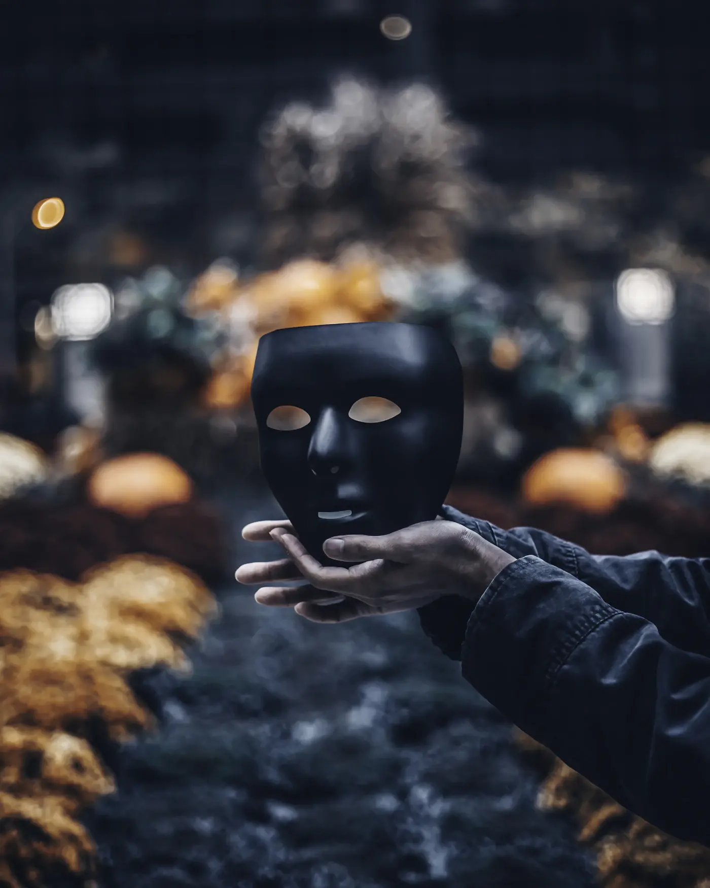 A person holding a dramatic black costume mask